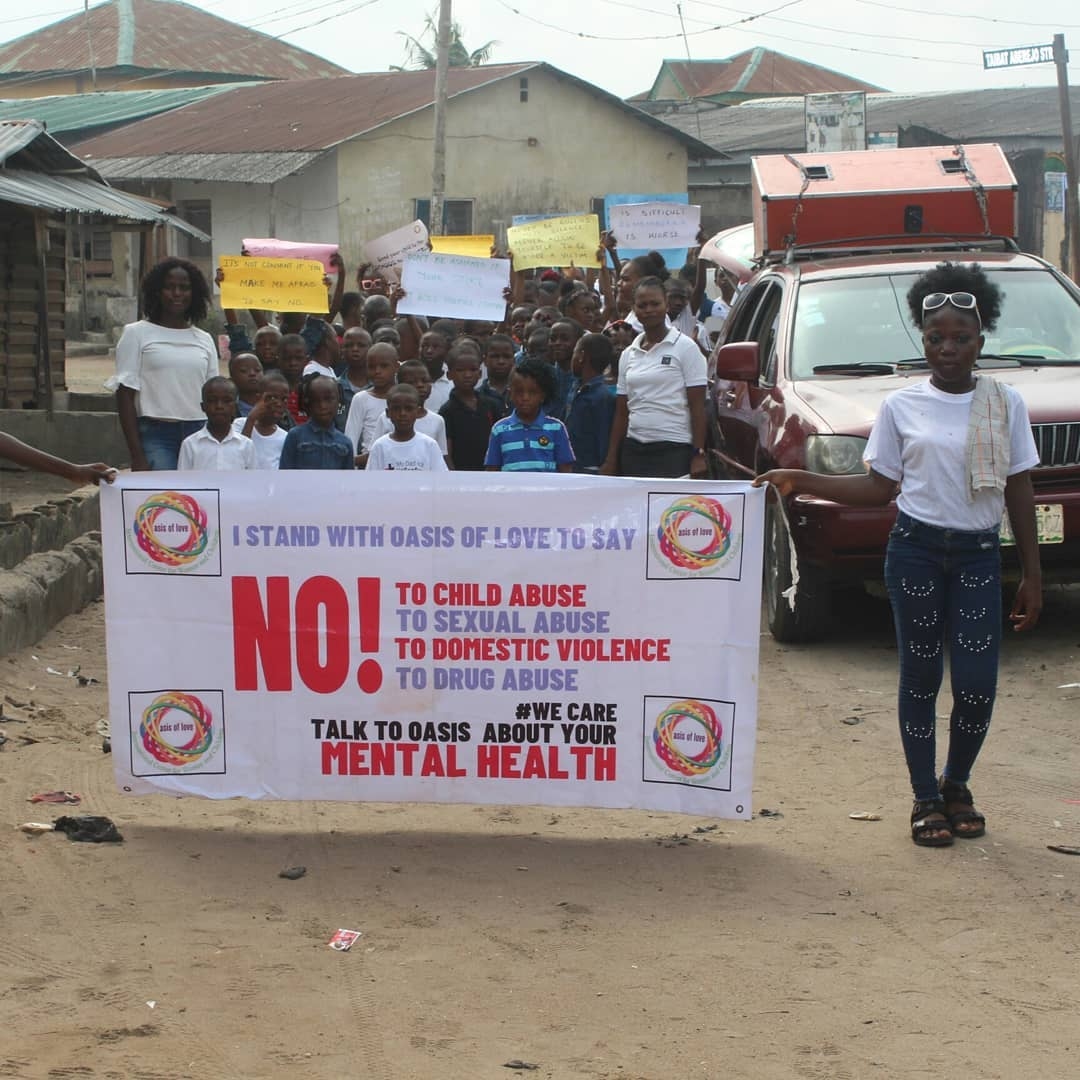 Children and OLIC volunteers holding the banner: Say NO to child abuse, sexual abuse, domestic violence and drug abuse
