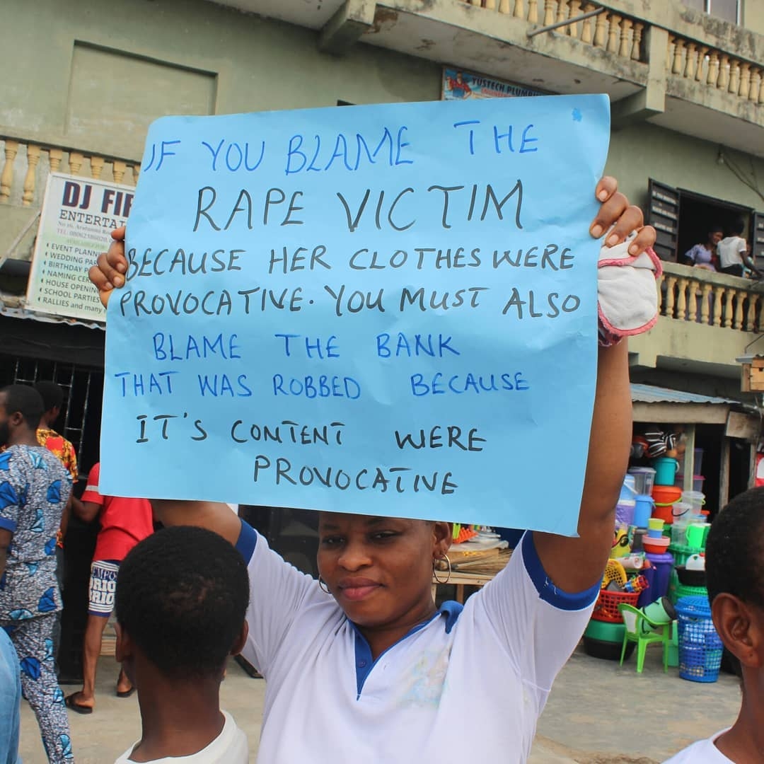 Campaigner holding a placard challenging victim-blaming