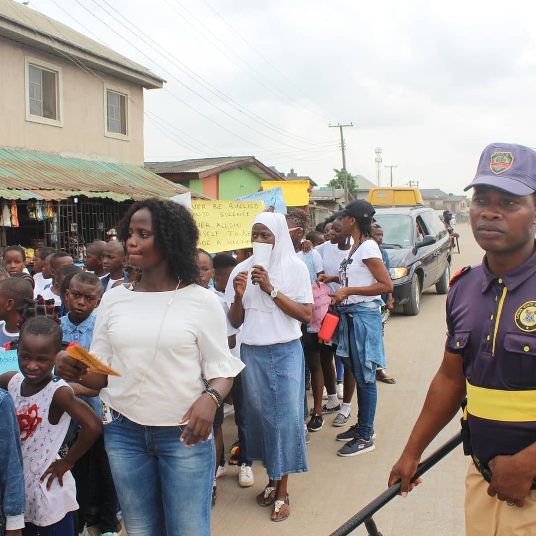 Volunteers and children marching through the community