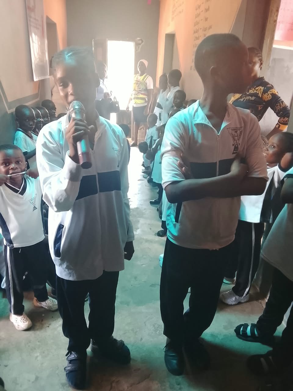 A young student speaking into the microphone while her classmates listen