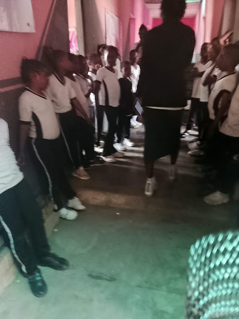 Pupils lined up in the school corridor, listening to the presenter