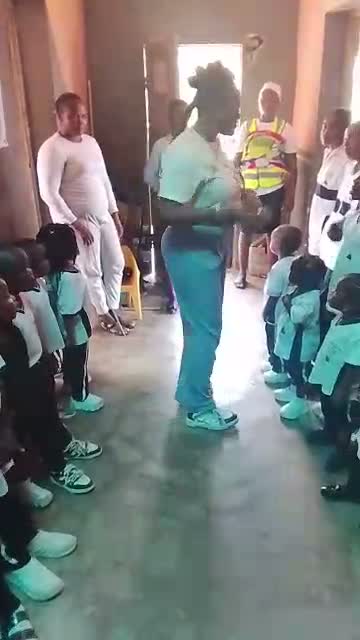 The presenter addressing two lines of pupils while teachers look on